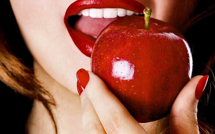 девушка кусает яблоко